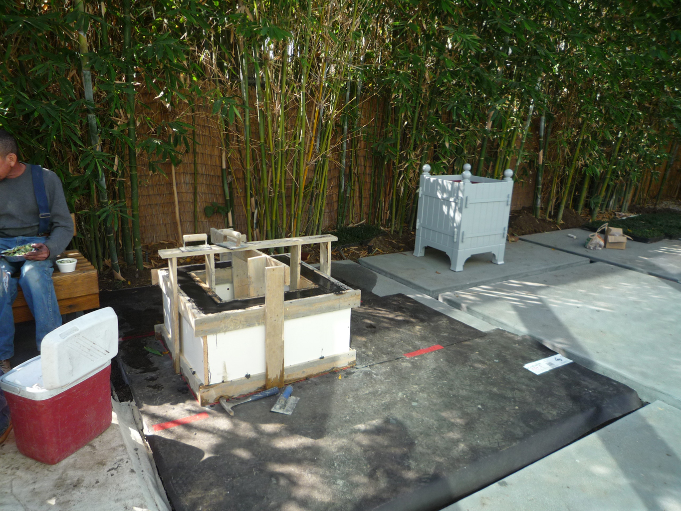 Construction of the firepit (framing) - 3.5" concrete thick walls - tinted, & smooth finish. Contemporary shape and material. Notice the Orangerie planter in the back